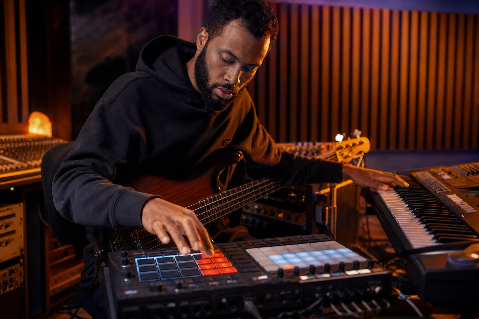 Producer sketching an R&B pocket with drum pads, bass notes, and electric piano chords
